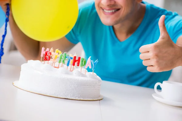 Young man celebrating birthday alone at home