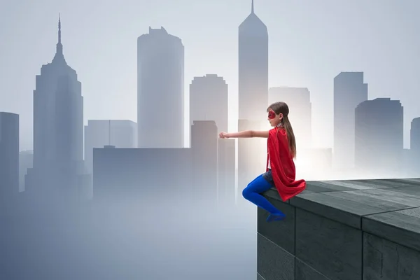 Молода дівчина в супергеройському костюмі з видом на місто — стокове фото
