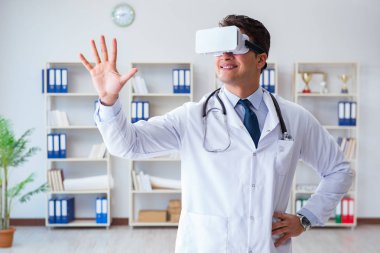 Sanal gerçeklik kulaklığı olan genç doktor ofiste çalışıyor.