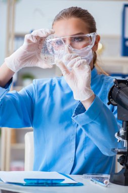 Bir laboratuarda deney yapan kadın bir bilim adamı.