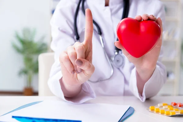 Läkare kardiolog med rött hjärta på sjukhuset — Stockfoto
