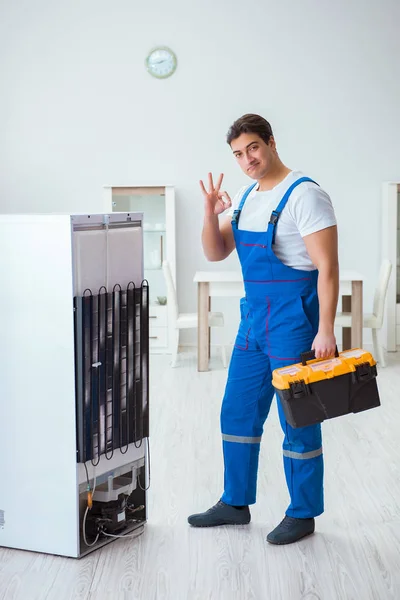 Repairman contractor repairing fridge in DIY concept