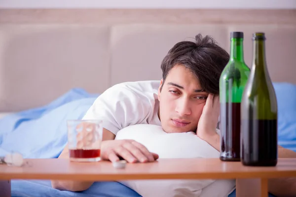 Man alkoholhaltiga drycker i sängen går igenom bryta upp depression — Stockfoto