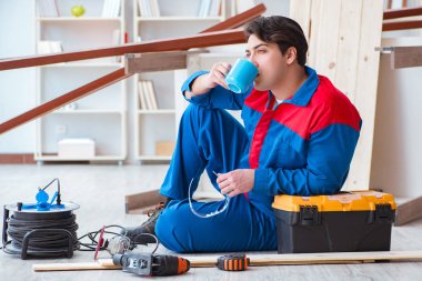 Genç marangoz ahşap kalaslarla çalışmaya ara veriyor.