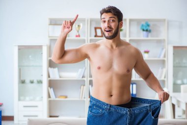 Kilo verme konseptinde büyük beden pantolon giyen bir adam.