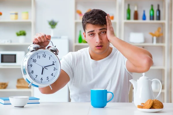 目覚まし時計を持った男が朝食で眠りにつく — ストック写真