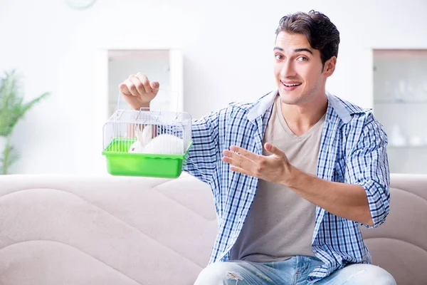 Jongeman spelen met huisdier konijn thuis — Stockfoto