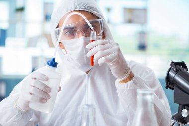 Laboratuvarda zehirli kimyasallarla çalışan bir kimyager.