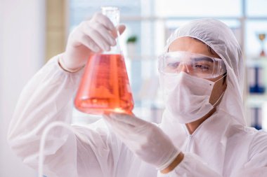 Laboratuvarda zehirli kimyasallarla çalışan bir kimyager.