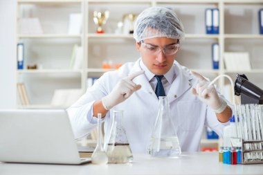 Genç araştırmacı bilim adamı bir su testi kirliliği araştırması yapıyor.