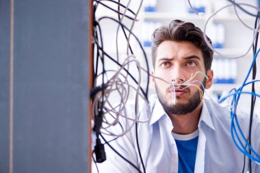 Elektrik teknisyeni tamir konseptinde kabloları çözmeye çalışıyor.