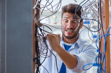 Elektrik teknisyeni tamir konseptinde kabloları çözmeye çalışıyor.