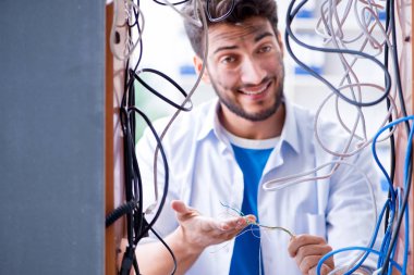 Elektrik teknisyeni tamir konseptinde kabloları çözmeye çalışıyor.