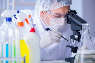 Laboratuvardaki adam yeni temizlik çözeltisi deterjanı test ediyor.
