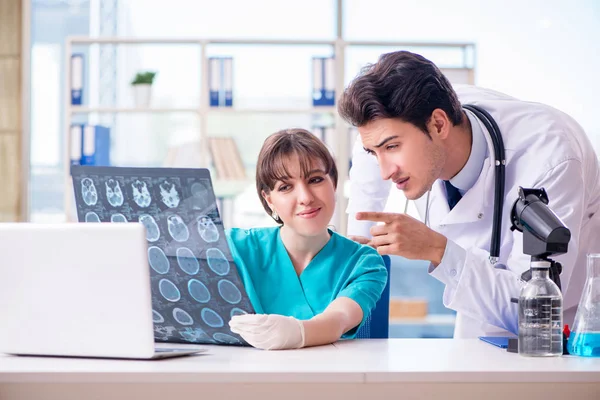 İki doktor hastanede röntgen görüntüsünü tartışıyor. — Stok fotoğraf