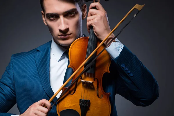 Jovem tocando violino no quarto escuro — Fotografia de Stock