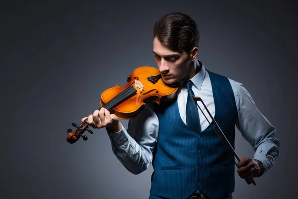 Jongeman viool spelen in donkere kamer — Stockfoto