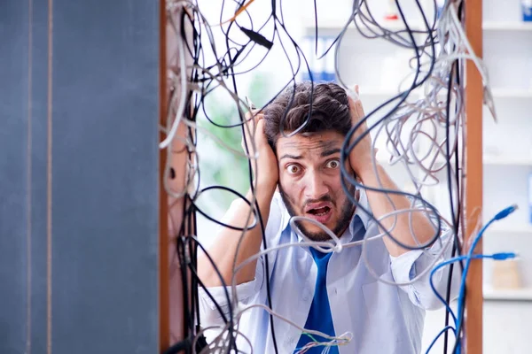 Electrician trying to untangle wires in repair concept — Stock Photo, Image