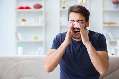 Genç adam estetik cerrahi burnundan sonra evde iyileşiyor.