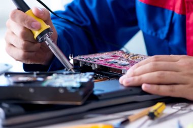 Bilgisayar dizüstü bilgisayarının tamirinde çalışan tamirci.