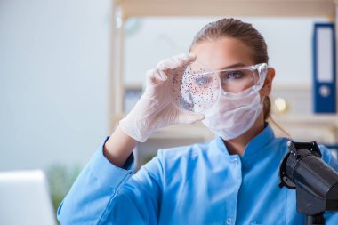 Bir laboratuarda deney yapan kadın bir bilim adamı.