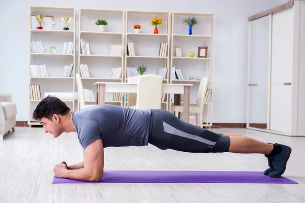 Junger Mann trainiert zu Hause mit Sport und gesundem Lebensstil — Stockfoto