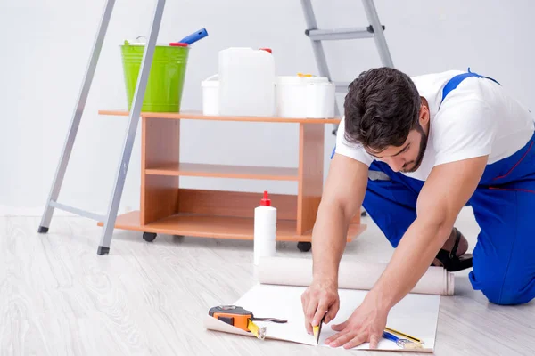 Reparador fazendo reparação de renovação na casa com papel wallpa — Fotografia de Stock