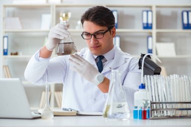 Genç araştırmacı bilim adamı bir su testi kirliliği araştırması yapıyor.