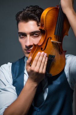 Genç müzisyen evde keman çalıyor.