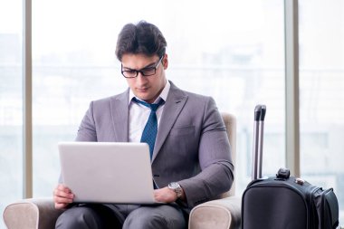 Havaalanındaki iş yerinde genç işadamı uçuş için bekliyor.