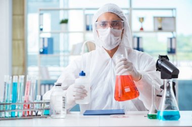 Laboratuvarda zehirli kimyasallarla çalışan bir kimyager.