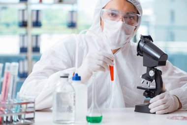 Laboratuvarda zehirli kimyasallarla çalışan bir kimyager.