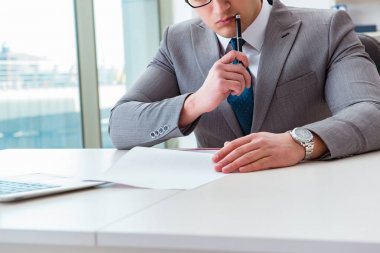 İşadamı ofiste iş belgelerini imzalıyor