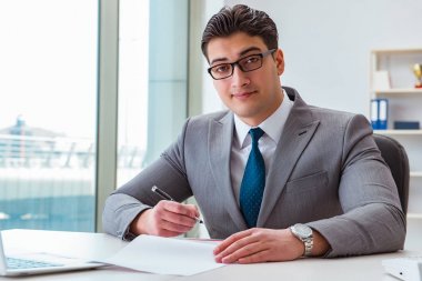 İşadamı ofiste iş belgelerini imzalıyor