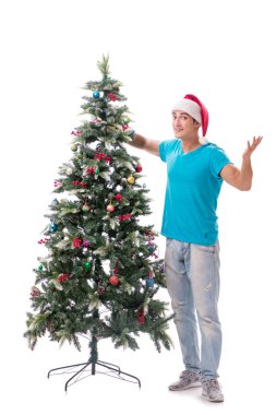 Genç adam beyaz üzerine izole edilmiş noel ağacını süslüyor.