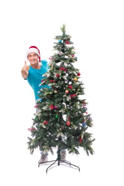 Genç adam beyaz üzerine izole edilmiş noel ağacını süslüyor.