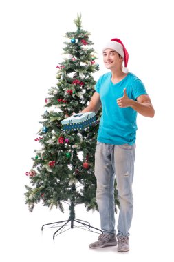 Genç adam beyaz üzerine izole edilmiş noel ağacını süslüyor.