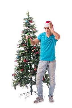 Genç adam beyaz üzerine izole edilmiş noel ağacını süslüyor.