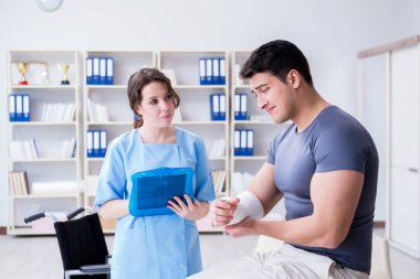 Hastanede yaralanma kontrolü sırasında doktor ve hasta.