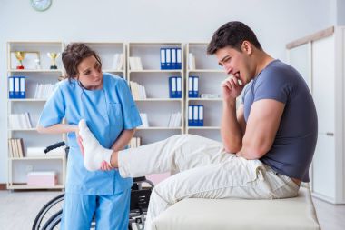 Hastanede yaralanma kontrolü sırasında doktor ve hasta.