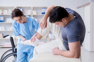 Hastanede yaralanma kontrolü sırasında doktor ve hasta.