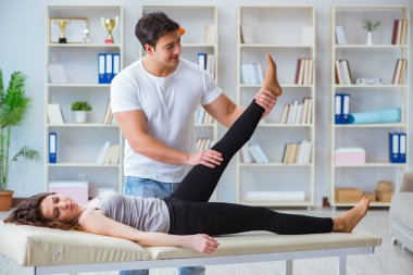 Genç doktor kayropraktik uzmanı kadın hastaya masaj yapıyor.