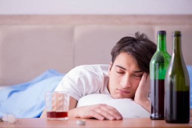 Yatakta içen alkolik adam depresyona giriyor.