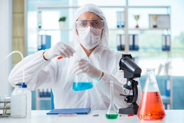 Químico trabalhando no laboratório com produtos químicos perigosos — Fotografia de Stock