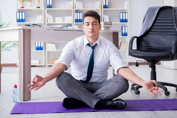 Adam stresle baş etmek için ofiste meditasyon yapıyor. — Stok fotoğraf