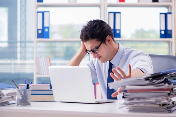 Businessman with excessive work paperwork working in office