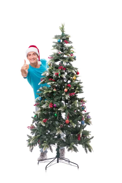 Genç adam beyaz üzerine izole edilmiş noel ağacını süslüyor.