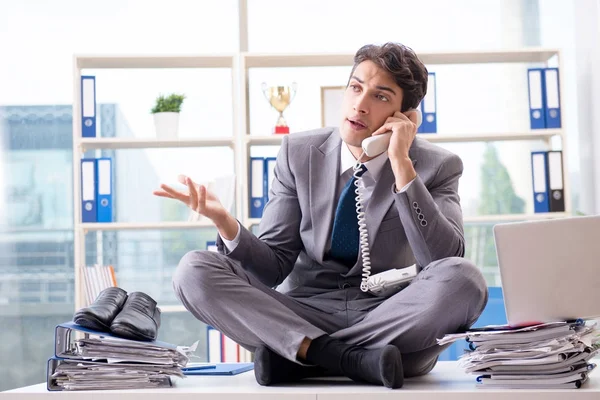 Geschäftsmann sitzt auf Schreibtisch im Büro — Stockfoto