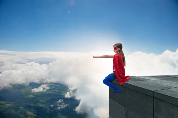 Chica joven en traje de superhéroe con vistas a la ciudad — Foto de Stock