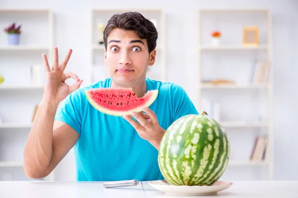 Man die thuis watermeloen eet — Stockfoto